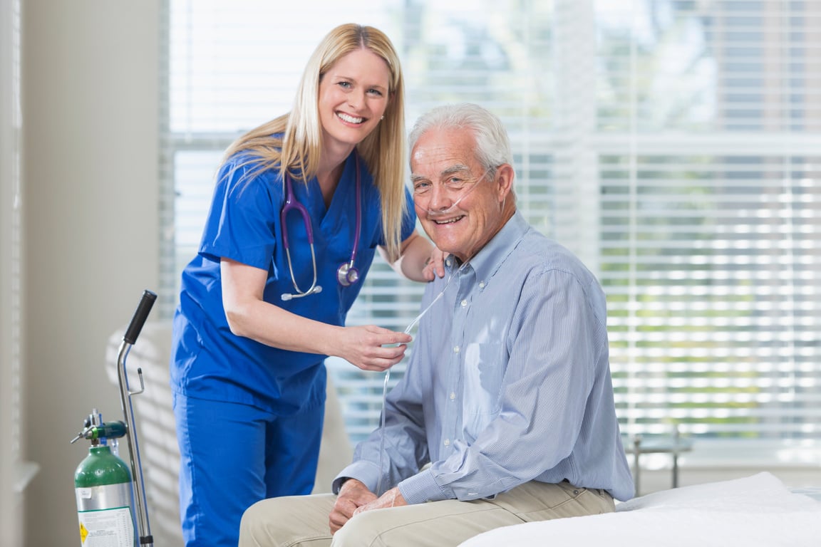 Home healthcare nurse helping elderly man with oxygen